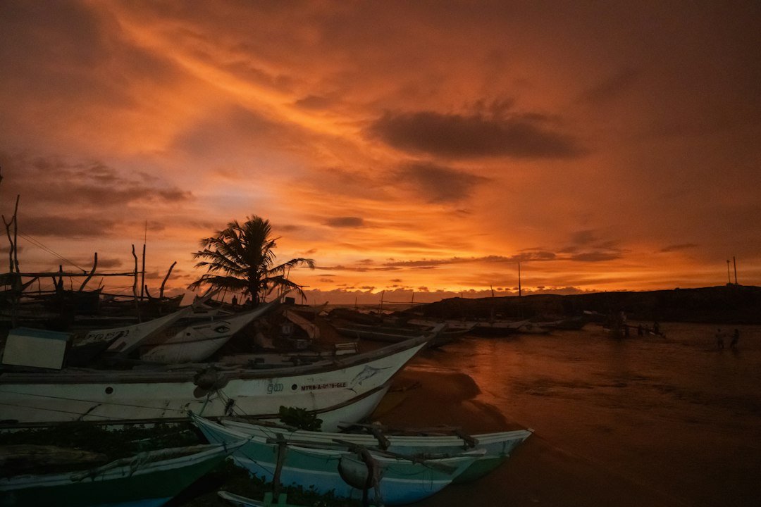Boats docked on calm water at sunset, representative of the outlook for Balochistan's coastal fishing communities