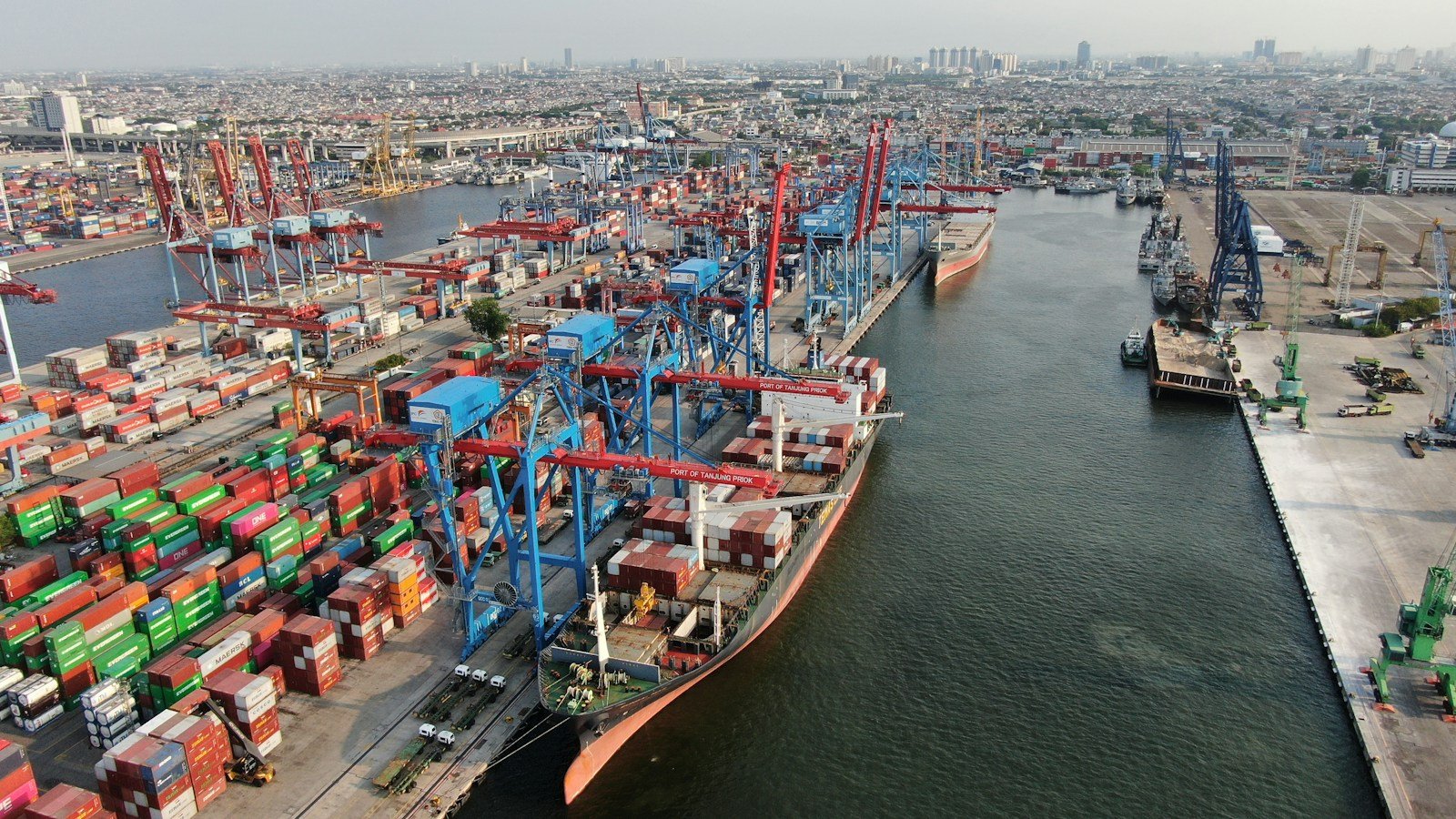 Cranes and stacked cargo containers at a busy shipping port, representative image for export logistics out of the Gwadar Free Zone