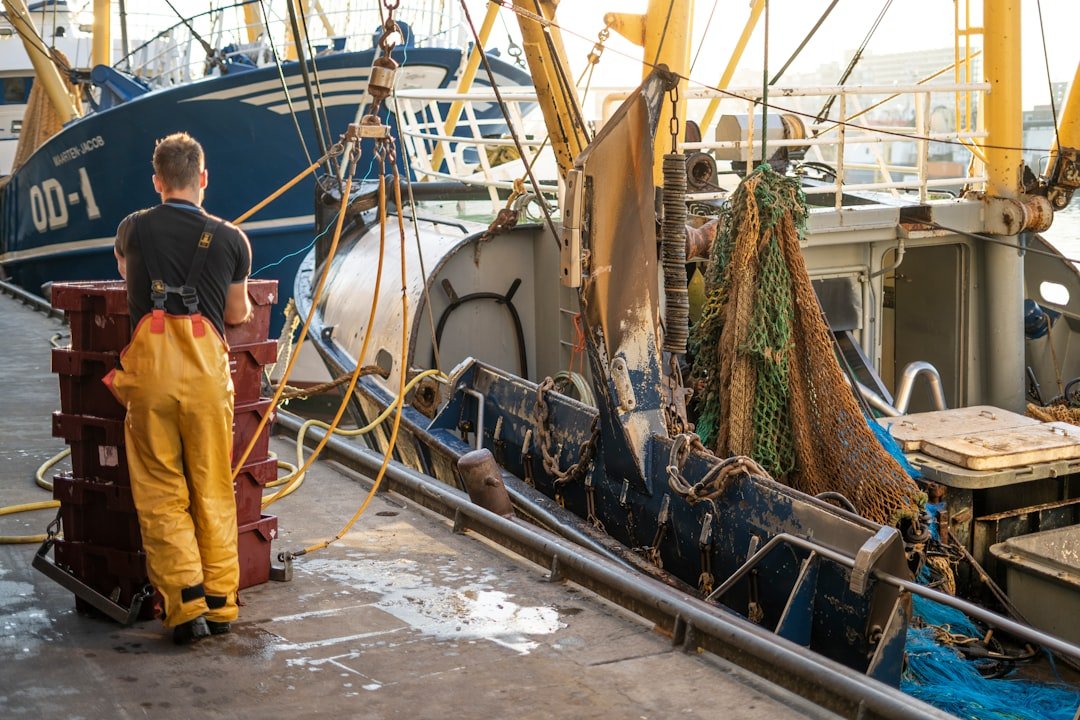 A fisherman standing beside his boat, representative of the boat registration and inspection drive underway along the Gwadar coast