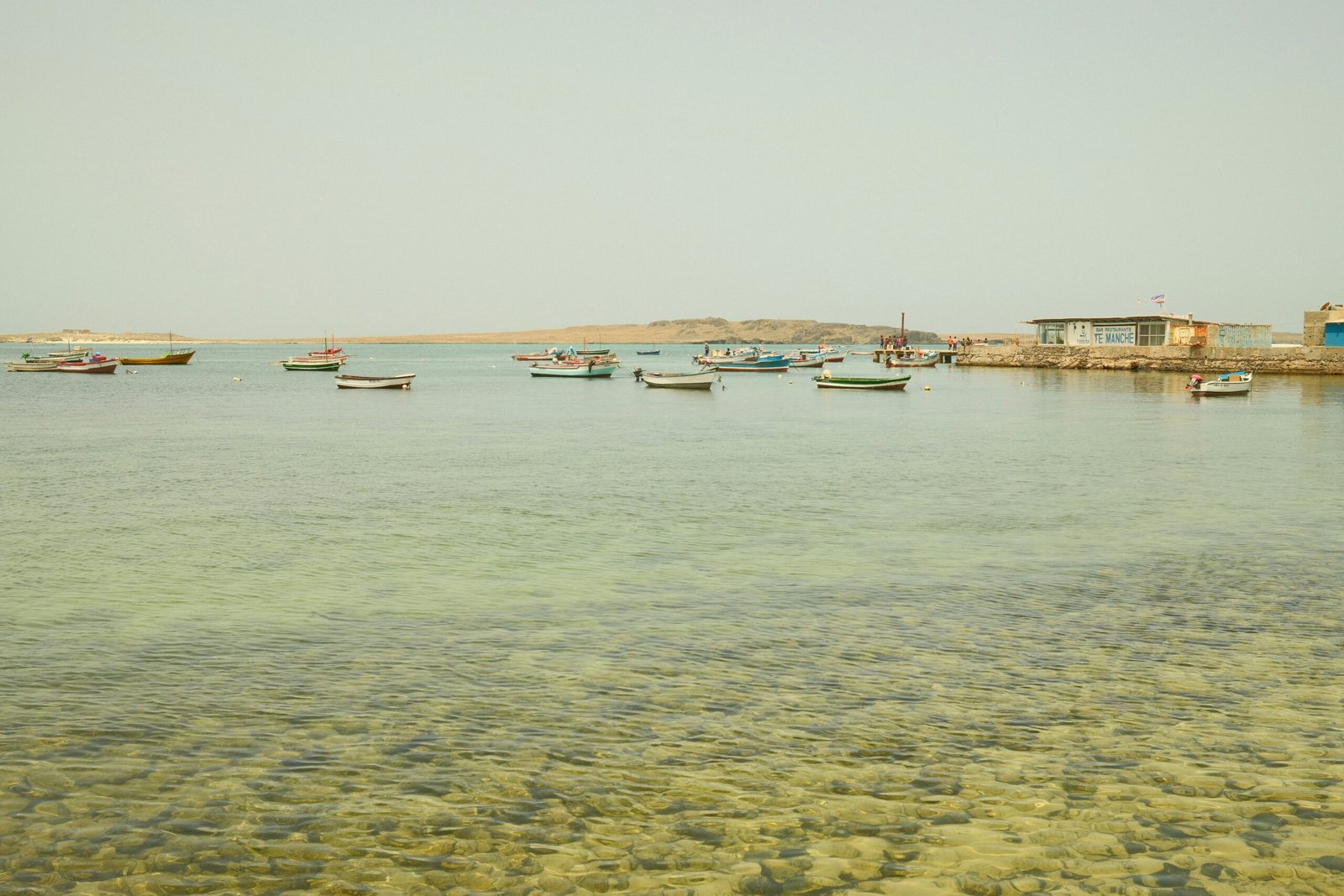 Small fishing boats anchored near a coastal pier, representing the new fish landing jetty and harbor planned for Gwadar's West Bay