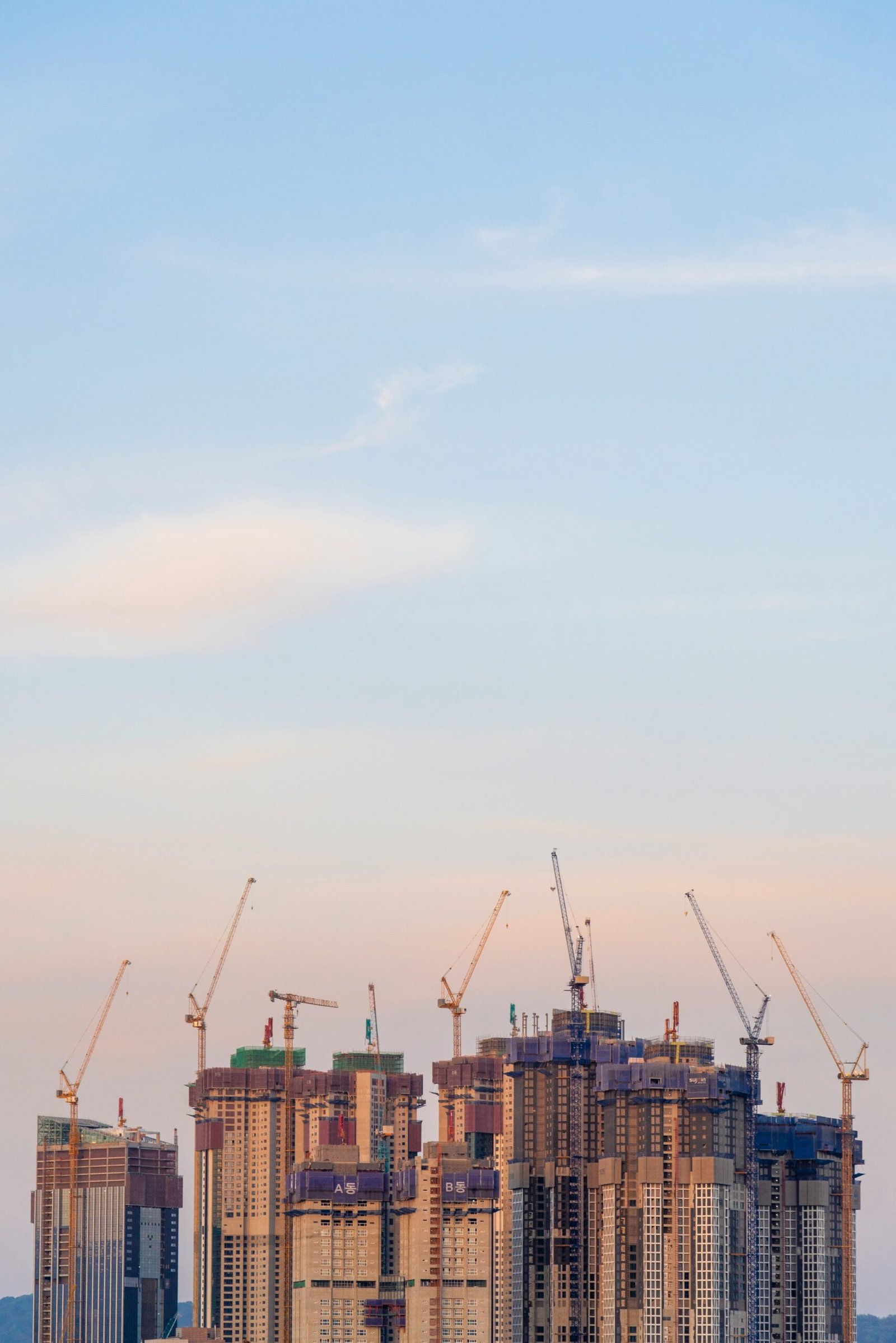 Construction cranes next to a building under construction, representative image for planned development under Gwadar's master plan