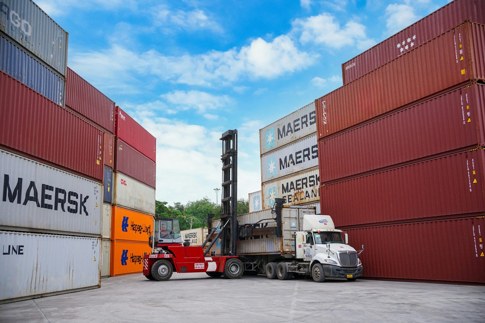 Shipping containers being moved by forklift at a logistics terminal, representative image of the warehousing and free-zone investment discussed for Gwadar