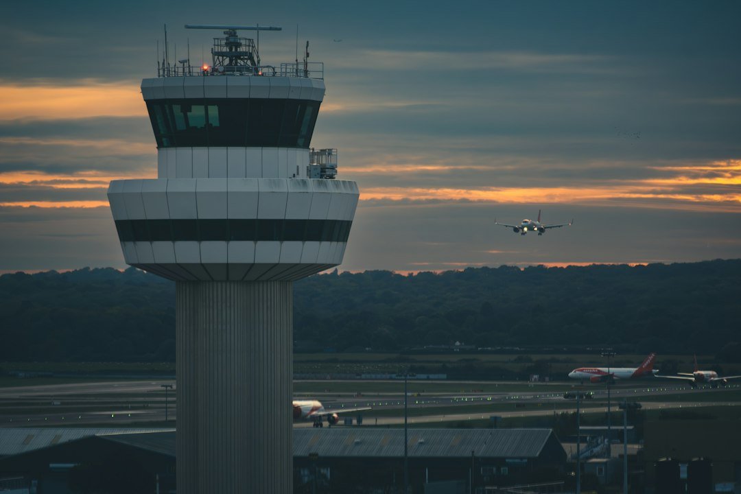 An airport control tower with an aircraft on approach at dusk, representative image for Pakistan's expanded federal airport infrastructure funding