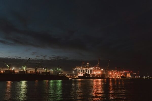 Illuminated industrial port with cranes reflecting on water at night, representative image for Gwadar's electricity supply challenges