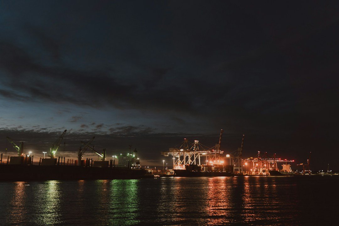 Illuminated industrial port with cranes reflecting on water at night, representative image for Gwadar's electricity supply challenges