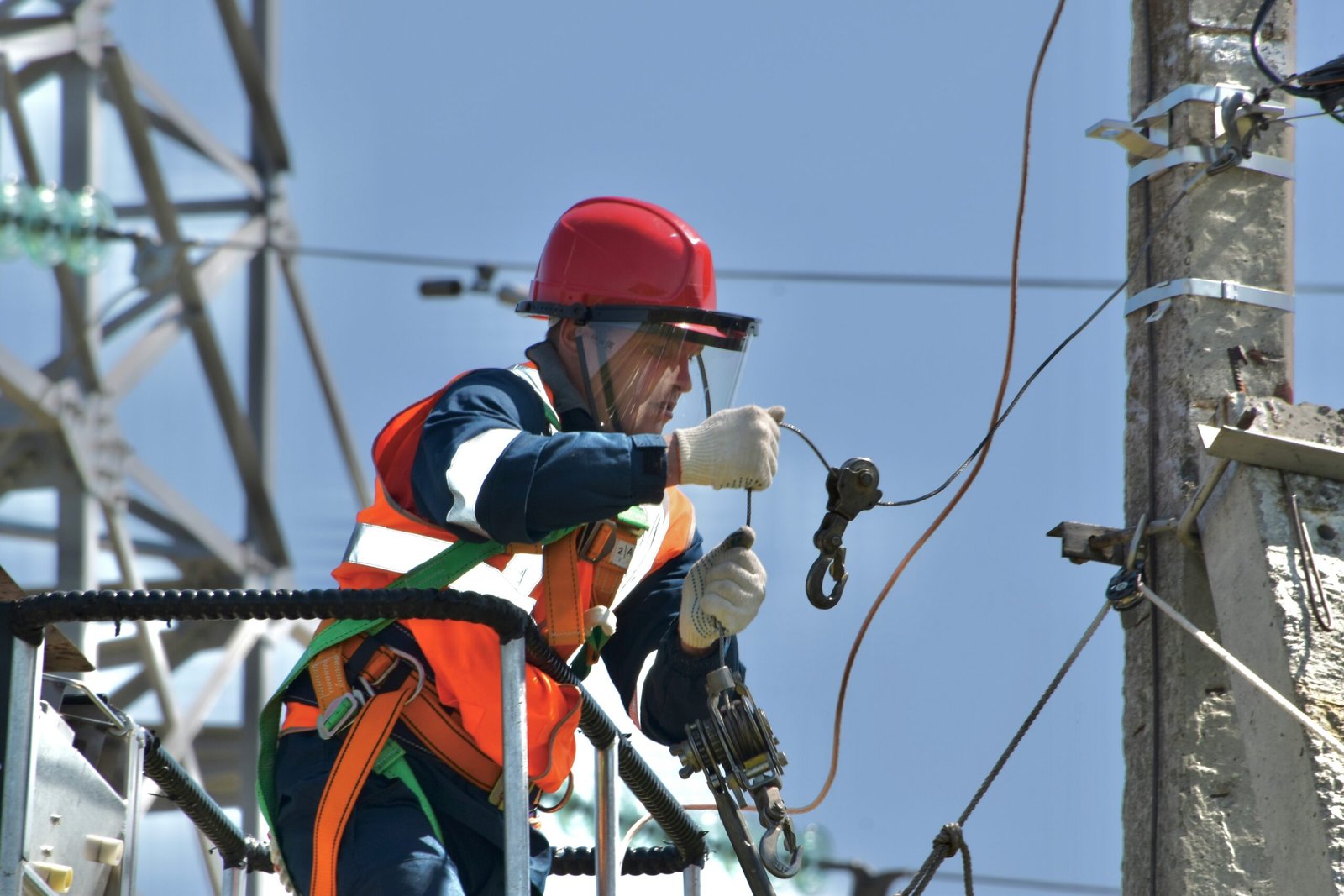 A utility worker in safety gear works on a pole, representative image for the underground cabling and pole installation work completed under Gwadar's Safe City Project