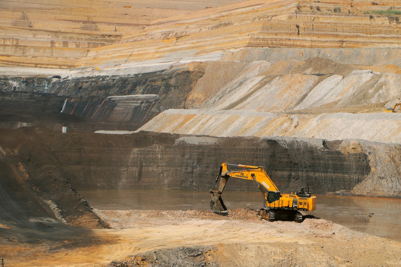 A yellow excavator working in a large open-pit mine, representative image for mineral and mining investment under CPEC 2.0's industrial cooperation push
