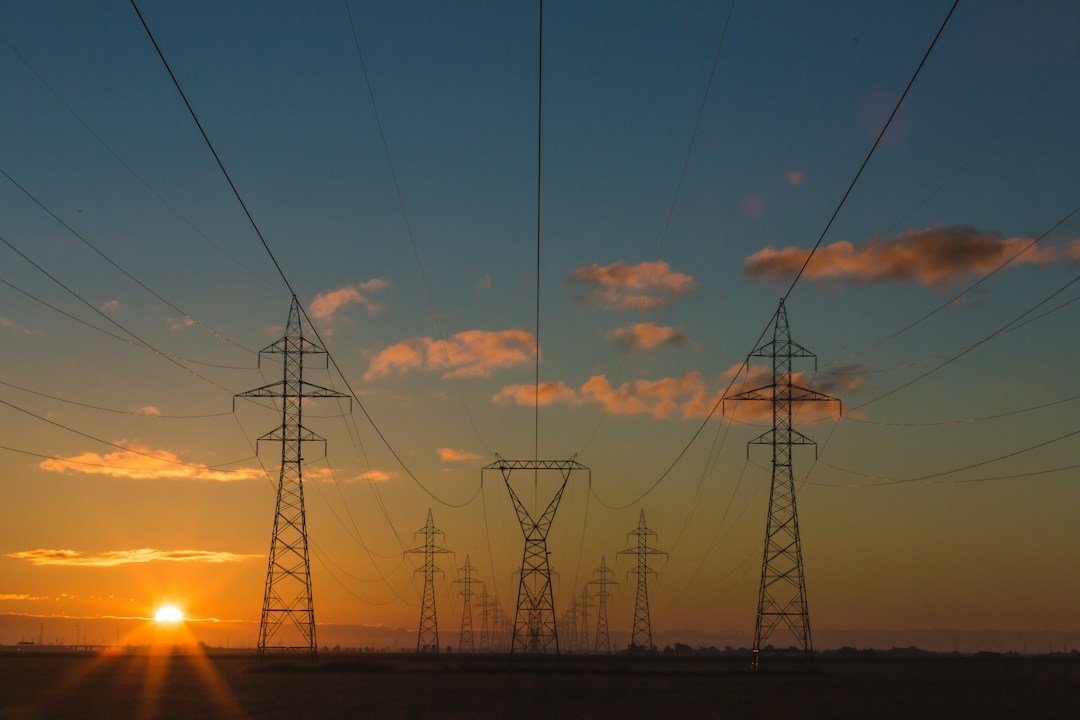 Electricity transmission towers and power lines at sunset, representative image for the cross-border power imports that supply Gwadar