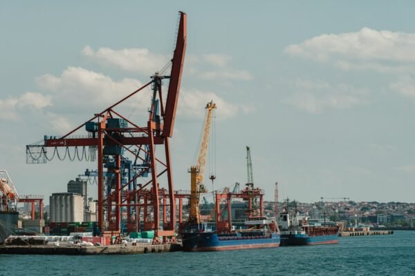 Shipping containers stacked at a sea freight terminal, featured image for the proposed Gwadar-Sohar sister-port agreement between Pakistan and Oman